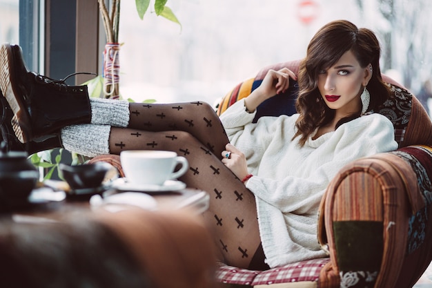 Free photo young girl drinking coffee in a trendy cafe