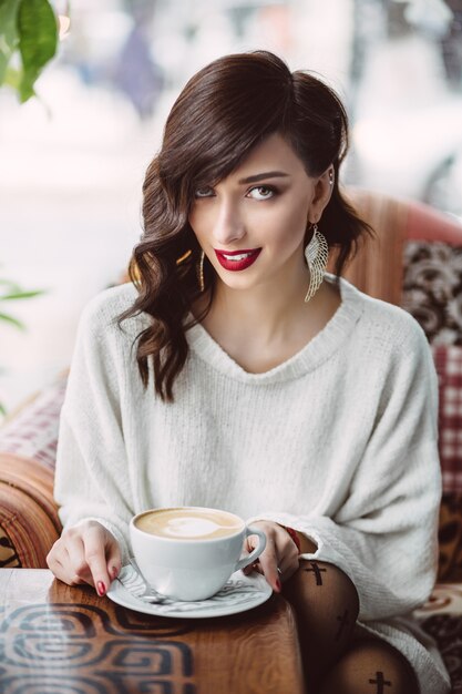 Young girl drinking coffee in a trendy cafe