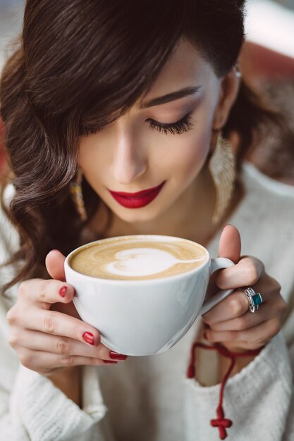 Young girl drinking coffee in a trendy cafe