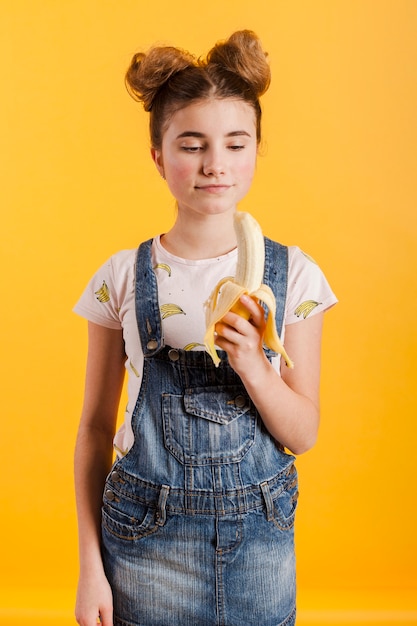 Young girl eating banana