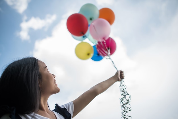 Free photo young girl hand holding colorful balloons