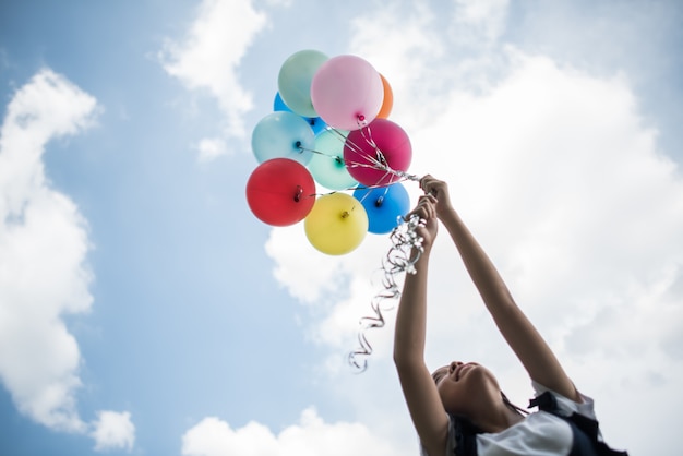 Free photo young girl hand holding colorful balloons