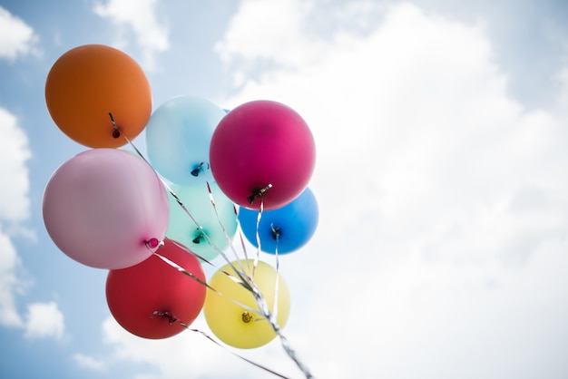 Free photo young girl hand holding colorful balloons