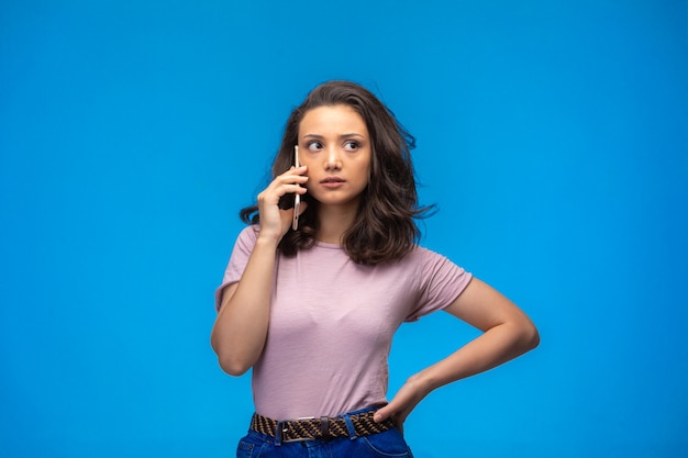 Free photo young girl having call at her smartphone and looks serious.