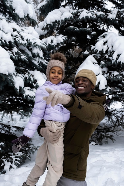 Young girl having fun with her father on a snowy winter day