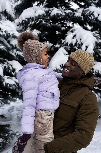 Young girl having fun with her father on a snowy winter day