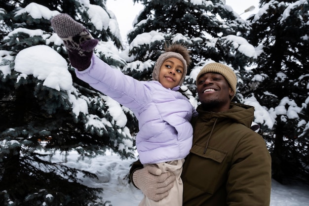 Young girl having fun with her father on a snowy winter day