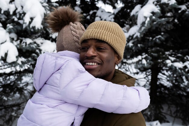 Young girl having fun with her father on a snowy winter day