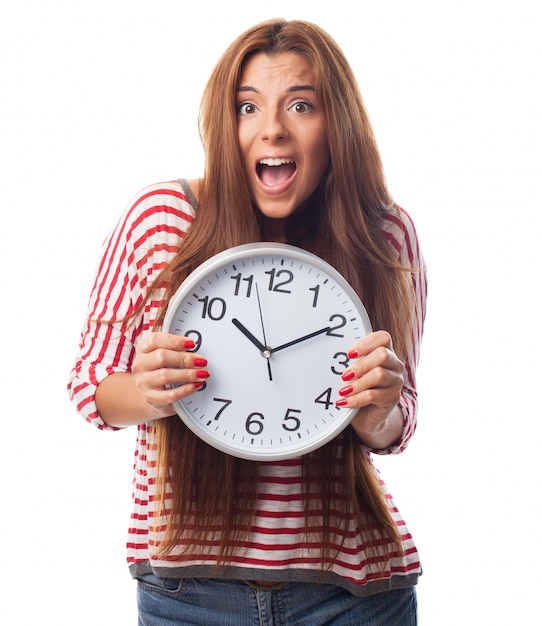 Free photo young girl hiding behind a clock.