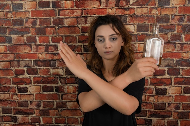 Free photo young girl holding alcohol and crossed her hands. high quality photo