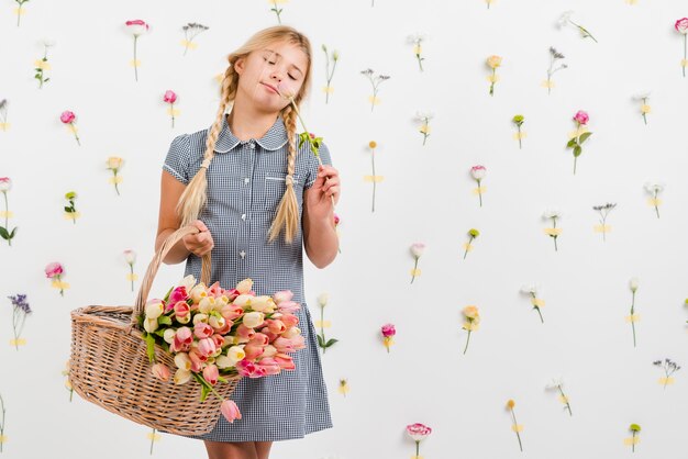 Young girl holding basket with flowers