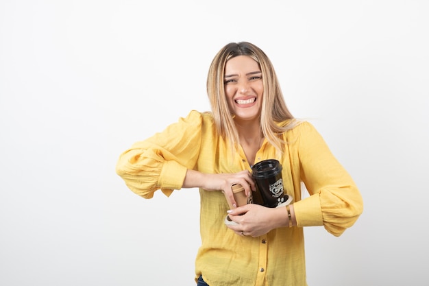 Free photo young girl holding cups of coffee on white.