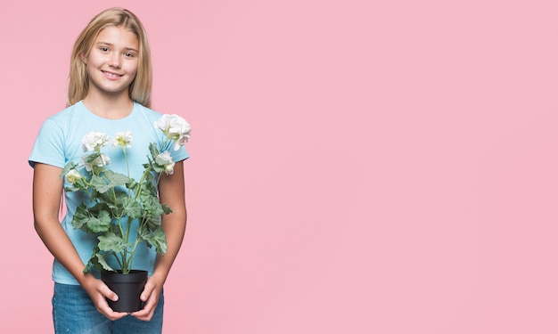 Free photo young girl holding flower pot