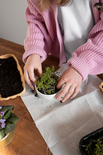 Young girl holding greenery planted in upcycled pot