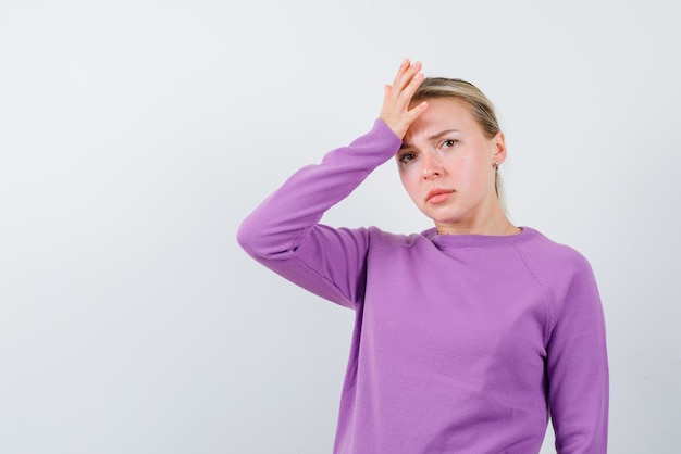 Young girl holding her hand on her forehead on white background