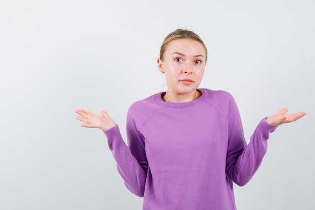 Young girl holding I don't know gesture on white background