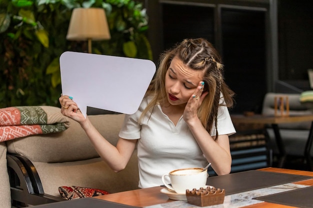 Young girl holding white idea board and looking at it