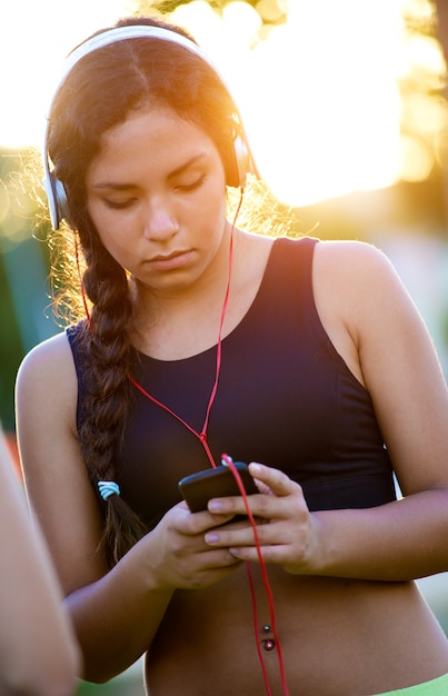 Free photo young girl listening to music with mobile phone.