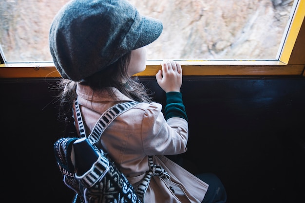 Free photo young girl looking at train window