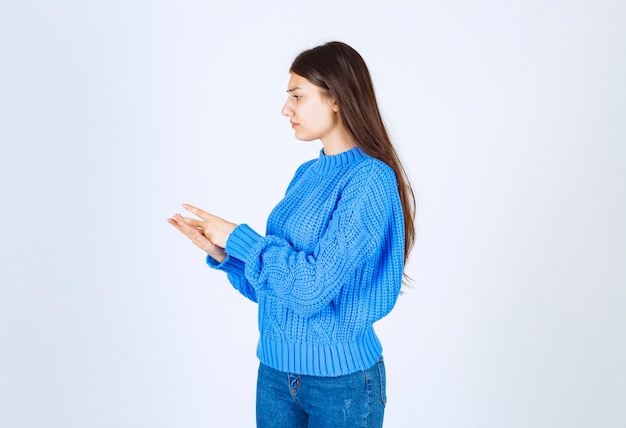 young girl model in blue sweater standing and posing on white-gray .