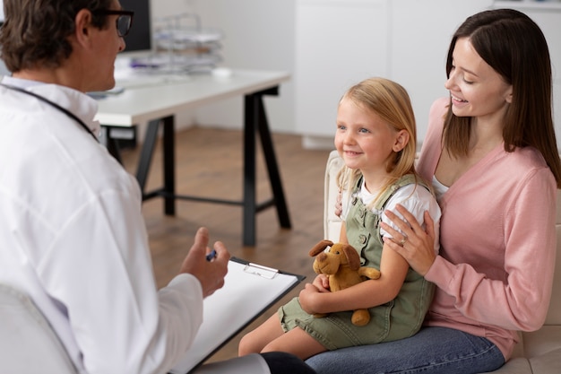 Young girl at the pediatrician for a consultation with her doctor and her mother