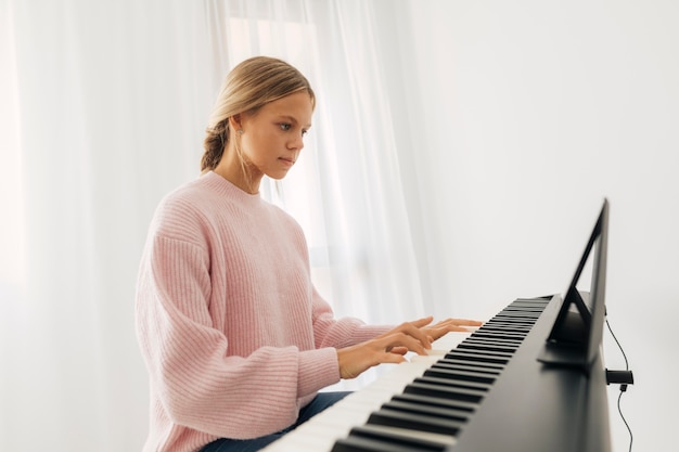 Young girl playing keyboard instrument at home