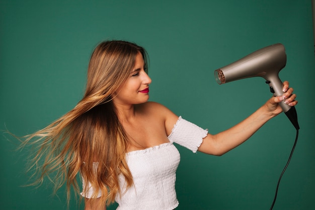 Young girl posing with hairdryer