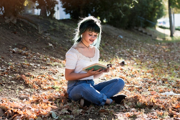 Young girl reading on sunny hill