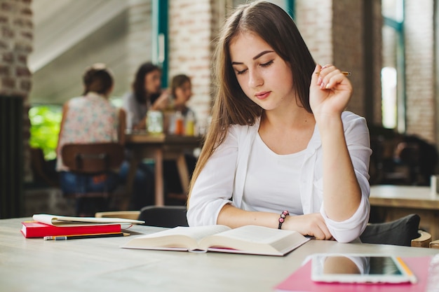 Young girl reading textbook