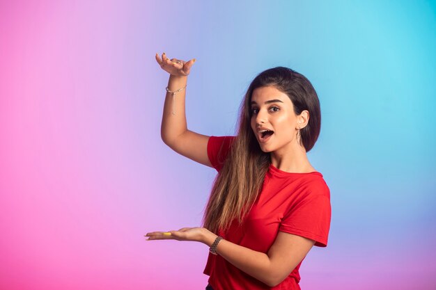 Young girl in red shirt showing dimensions.