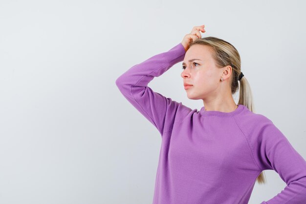 Young girl scratching her head and thinking on white background