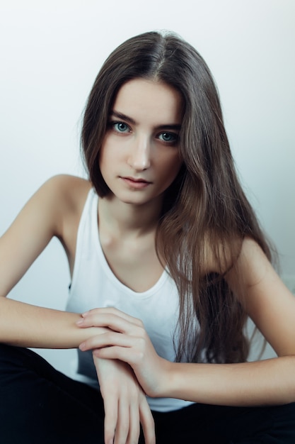 Free photo young girl sitting on the floor with one hand over another