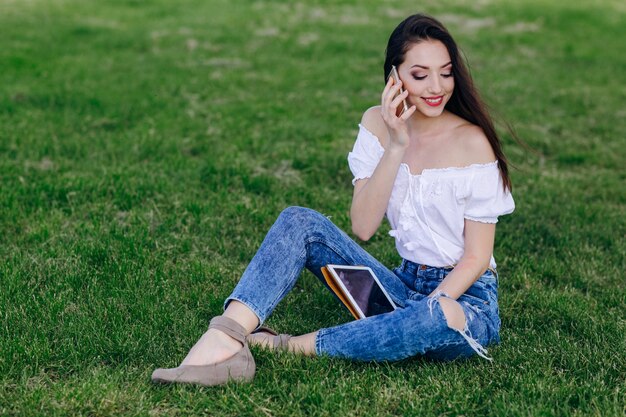 Young girl sitting in a park talking on the phone