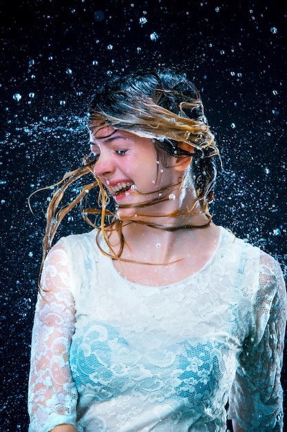 Free photo young girl standing under running water