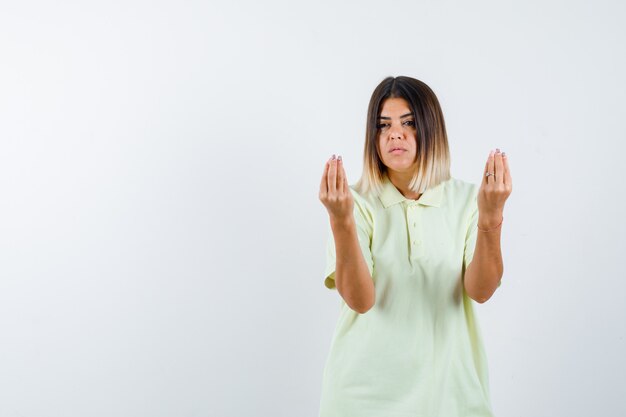 Young girl in t-shirt showing Italian gesture and looking serious , front view.