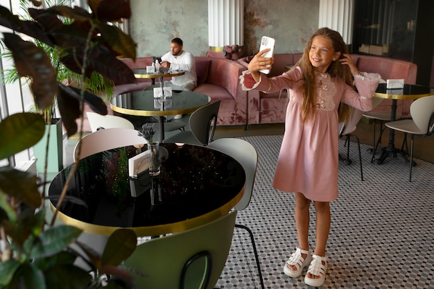 Free Photo young girl taking a selfie at restaurant