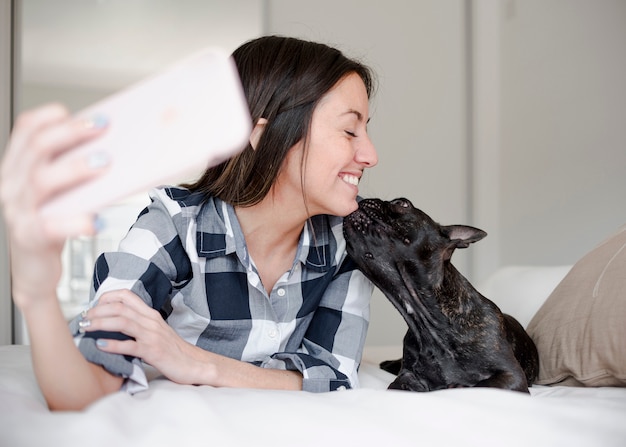 Free photo young girl taking a selfie with her doggie