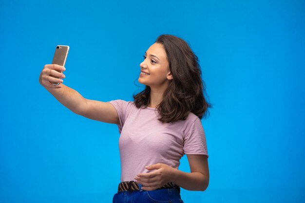 Young girl taking selfie with her smartphone. 