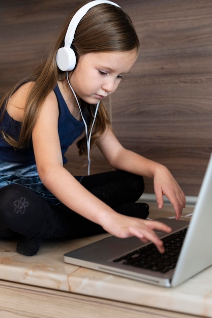 Young girl using laptop with headphones