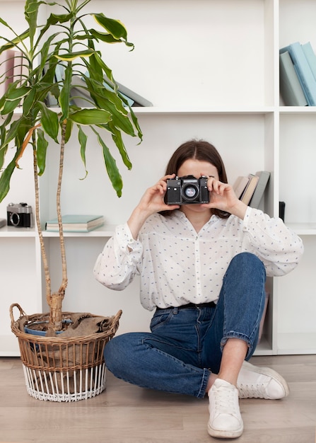 Free photo young girl in white shirt using an old camera