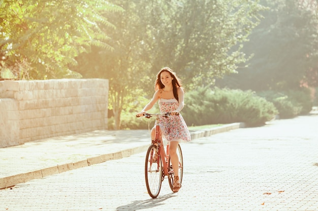 The young girl with bicycle in park