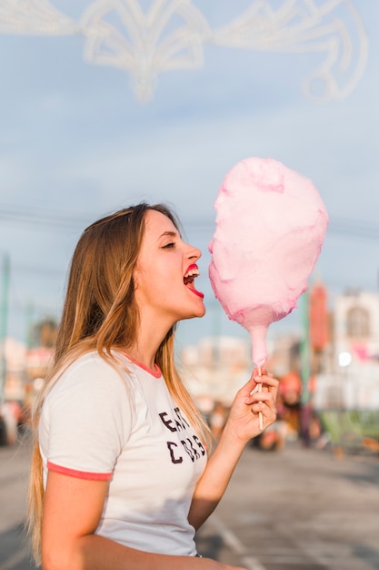 Free Photo young girl with cotton candy in the amusement park