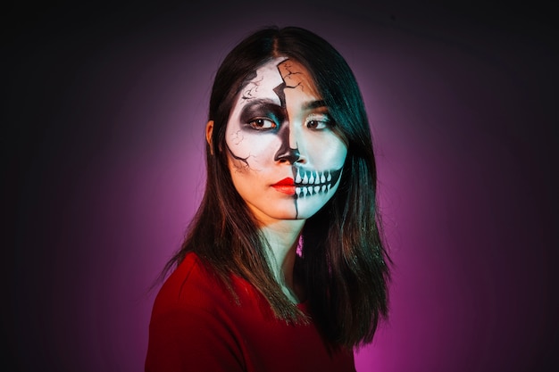 Young girl with makeup and halloween mask