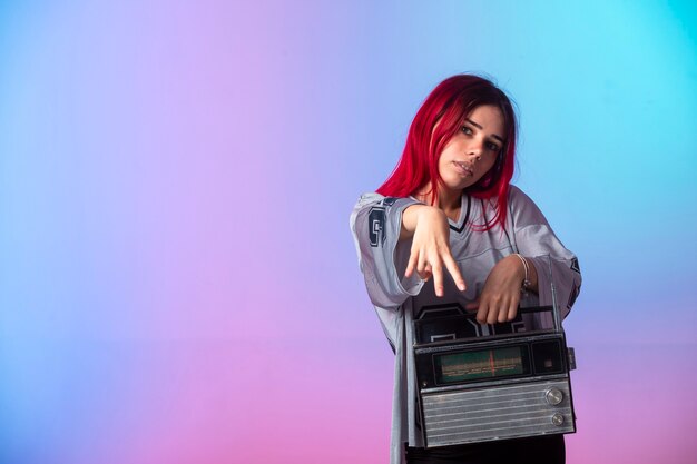 Free photo young girl with pink hairs holding a vintage radio.