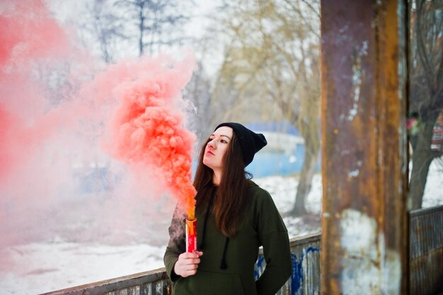 Young girl with red colored smoke bomb in hand