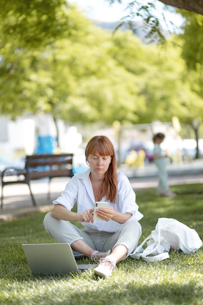 Young girl working on a computer in the park