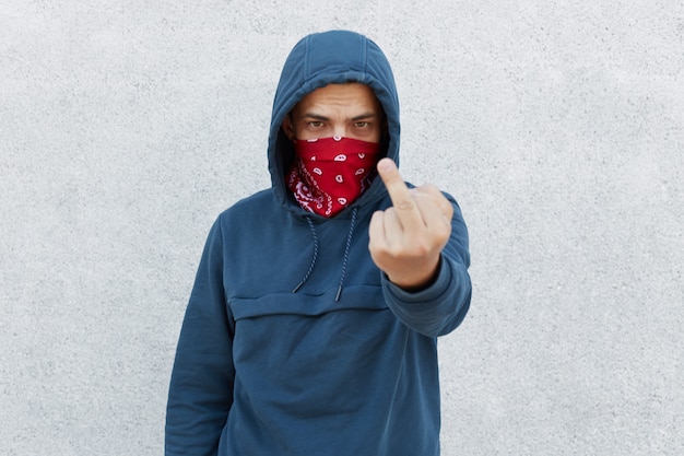 Free photo young guy in bandana mask calls for stopping police brutality, showing middle finger