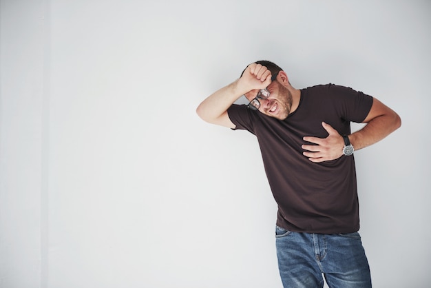 Free photo a young guy in casual clothes holds on to the heart and the head