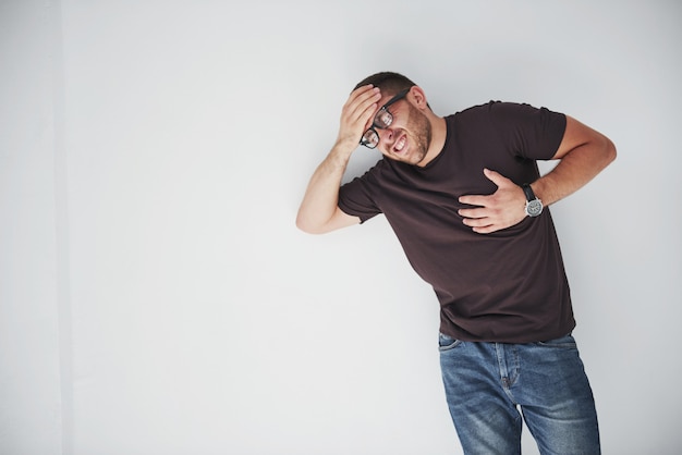 Free photo a young guy in casual clothes holds on to the heart and the head