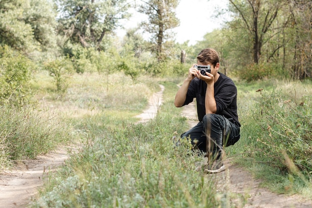 Free Photo young guy taking pictures in nature with copy-space